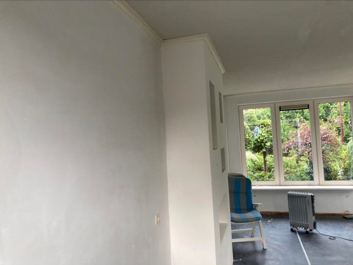 Vers gestucte kamer met erker en uitzicht op de tuin