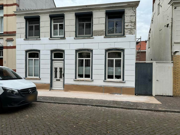 Voor: De gevel zoals hij was: oude, verweerde pleisterlaag.